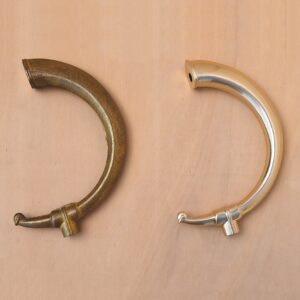 un braccio di applique in ottone grezzo a confronto con uno lucidato